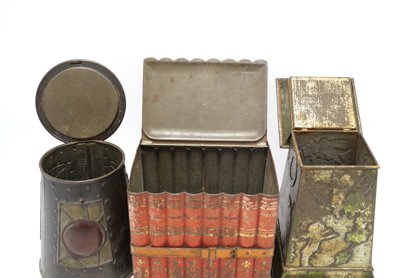 Three early 20th century Huntley & Palmer novelty biscuit tins, modelled as bound books, a sun dial and an Arts & Crafts lantern, largest 24cm high. Condition - fair